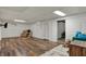 Spacious finished basement with wood-look flooring, a comfortable chair, and a tv at 1123 Woodbridge Ln, Indianapolis, IN 46260
