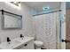 Stylish bathroom with a double vanity, a modern mirror, and a shower with a patterned curtain at 1123 Woodbridge Ln, Indianapolis, IN 46260