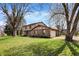 A lovely view of the 2-story Tudor-style home with green grass and mature trees at 1123 Woodbridge Ln, Indianapolis, IN 46260