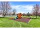 A colorful playground featuring slides, swings, and climbing structures, surrounded by lush green grass and trees at 1123 Woodbridge Ln, Indianapolis, IN 46260