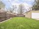 Large backyard with a well-kept lawn, wooden fence, and detached one-car garage at 1139 N Butler Ave, Indianapolis, IN 46219
