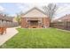 Exterior backyard of home with seating, trimmed lawn, and privacy fencing at 1139 N Butler Ave, Indianapolis, IN 46219
