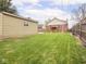 Spacious backyard featuring a large detached garage, manicured lawn, and a charming brick house at 1139 N Butler Ave, Indianapolis, IN 46219