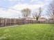 Large backyard with a well-maintained lawn, wooden fence, and space for outdoor activities at 1139 N Butler Ave, Indianapolis, IN 46219