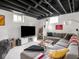 Finished basement features an exposed ceiling, modern finishes, and a comfortable entertainment area at 1139 N Butler Ave, Indianapolis, IN 46219