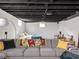 Spacious finished basement featuring a large sectional couch, open ceiling, and a bedroom area at 1139 N Butler Ave, Indianapolis, IN 46219