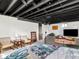 Open finished basement featuring a combined living and bedroom area with an exposed ceiling at 1139 N Butler Ave, Indianapolis, IN 46219