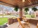 Inviting front porch with wooden table and chairs, and hanging plants creating a cozy outdoor space at 1139 N Butler Ave, Indianapolis, IN 46219