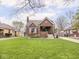 Charming brick home featuring a well-manicured lawn, landscaped garden beds, and a cozy covered front porch at 1139 N Butler Ave, Indianapolis, IN 46219