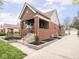 Charming brick home with a well-manicured front yard, covered porch, and landscaped garden beds at 1139 N Butler Ave, Indianapolis, IN 46219