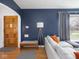 Inviting living room with hardwood floors, a cozy sofa, and a wooden front door at 1139 N Butler Ave, Indianapolis, IN 46219