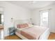 Bright main bedroom with hardwood floors, neutral colors, and bedside tables at 1139 N Butler Ave, Indianapolis, IN 46219