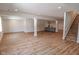 Spacious finished basement with wood-look flooring, bar area and stairs at 11640 Ansley Ct, Zionsville, IN 46077