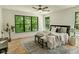 Sun-filled bedroom showcasing a ceiling fan, a cozy rug, and views of lush greenery outside at 11640 Ansley Ct, Zionsville, IN 46077