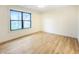 Bright, empty bedroom with hardwood floors and a large window offers versatile living space at 11640 Ansley Ct, Zionsville, IN 46077