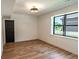 Bright bedroom featuring wood-look floors, a modern light fixture, and a large window with abundant natural light at 11640 Ansley Ct, Zionsville, IN 46077