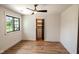 Bedroom boasts wood-look floors, modern ceiling fan, and closet with built-in drawers, illuminated by a window at 11640 Ansley Ct, Zionsville, IN 46077