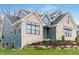 Elegant two-story home with stone and siding exterior, complemented by lush landscaping and mature trees at 11640 Ansley Ct, Zionsville, IN 46077