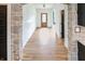 Hallway featuring stone archway, wood floors, and a wooden door, offering a view to rooms beyond at 11640 Ansley Ct, Zionsville, IN 46077