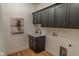 Functional laundry room with gray cabinets, sink, and stylish fixtures at 11640 Ansley Ct, Zionsville, IN 46077