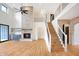 Open-concept living room with stone fireplace, hardwood floors, and staircase at 11640 Ansley Ct, Zionsville, IN 46077
