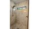 Modern shower with marble tile, rainfall showerhead, and window for natural light at 11640 Ansley Ct, Zionsville, IN 46077
