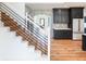Elegant staircase leading to an open entryway and views of the modern kitchen at 11640 Ansley Ct, Zionsville, IN 46077