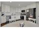 Updated kitchen features white cabinets, modern stainless steel appliances, and a bright dining area at 12030 Driftstone Dr, Fishers, IN 46037