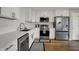 Bright kitchen with stainless appliances, white cabinetry, and a view of the dining area at 12030 Driftstone Dr, Fishers, IN 46037