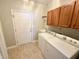 Practical laundry room features wood cabinets, utility sink, and included washer and dryer at 1238 Passage Way, Plainfield, IN 46168