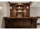 Wet bar features rich wood cabinetry, decorative lighting, and ample counter space for hosting guests at 12813 Chapel Square St, Carmel, IN 46032
