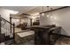 Basement wet bar with granite countertop, custom wood cabinets, and stylish pendant lighting near seating at 12813 Chapel Square St, Carmel, IN 46032