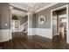 Inviting foyer featuring a chandelier, wainscoting, hardwood floors, and staircase at 12813 Chapel Square St, Carmel, IN 46032