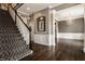 Staircase leads to an open foyer with hardwood floors and a decorative chandelier at 12813 Chapel Square St, Carmel, IN 46032