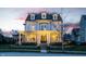 Elegant home exterior with a covered front porch, stone landscaping, and charming curb appeal at dusk at 12813 Chapel Square St, Carmel, IN 46032