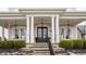 Inviting front porch featuring classic columns, hanging lanterns, and comfortable rocking chairs at 12813 Chapel Square St, Carmel, IN 46032