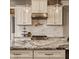 Close-up of kitchen featuring stainless steel appliances, custom cabinetry, and a stunning granite island at 12813 Chapel Square St, Carmel, IN 46032