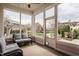 Inviting sunroom with large windows, wicker furniture, and a ceiling fan, offering serene views of the surrounding landscape at 12813 Chapel Square St, Carmel, IN 46032