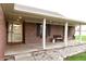 Inviting covered front porch features a bench, flower boxes, and a stylish front door at 13116 N Departure W Blvd, Camby, IN 46113