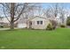 A single-story home with a brick facade, attached garage, and a green lawn with landscaping at 1313 Roseway Dr, Indianapolis, IN 46219