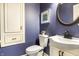 Stylish powder room with blue walls, white vanity, and elegant round mirror at 1320 Bittersweet Dr, Greenfield, IN 46140