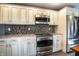 A kitchen features stainless steel appliances, light cabinetry, and dark mosaic backsplash at 1320 Bittersweet Dr, Greenfield, IN 46140