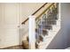 Carpeted staircase featuring decorative wrought iron railing and white trim at 1320 Bittersweet Dr, Greenfield, IN 46140
