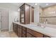 Elegant bathroom with dual sinks, quartz countertops, rich wood cabinets, and a tiled shower with glass door at 13245 E 131St St, Fishers, IN 46037