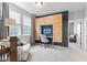 Stylish bonus room boasts a unique wood paneled wall with built-in desk and plush gray carpet, plus large windows at 13245 E 131St St, Fishers, IN 46037