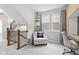 Inviting bonus room features neutral decor, gray carpet, a work space, and a comfortable chair by large window at 13245 E 131St St, Fishers, IN 46037