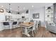 Open-concept dining room with farmhouse table, modern bar stools, and view of the kitchen at 13245 E 131St St, Fishers, IN 46037
