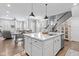 Bright kitchen with island, stainless steel appliances, white cabinets, and open concept to dining and living area at 13245 E 131St St, Fishers, IN 46037