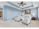 Spacious main bedroom boasts tray ceiling, soothing blue walls, and comfortable sitting area with great natural light at 13245 E 131St St, Fishers, IN 46037