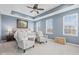 Serene main bedroom with tray ceiling, ceiling fan, large windows, and sitting area with two chairs at 13245 E 131St St, Fishers, IN 46037